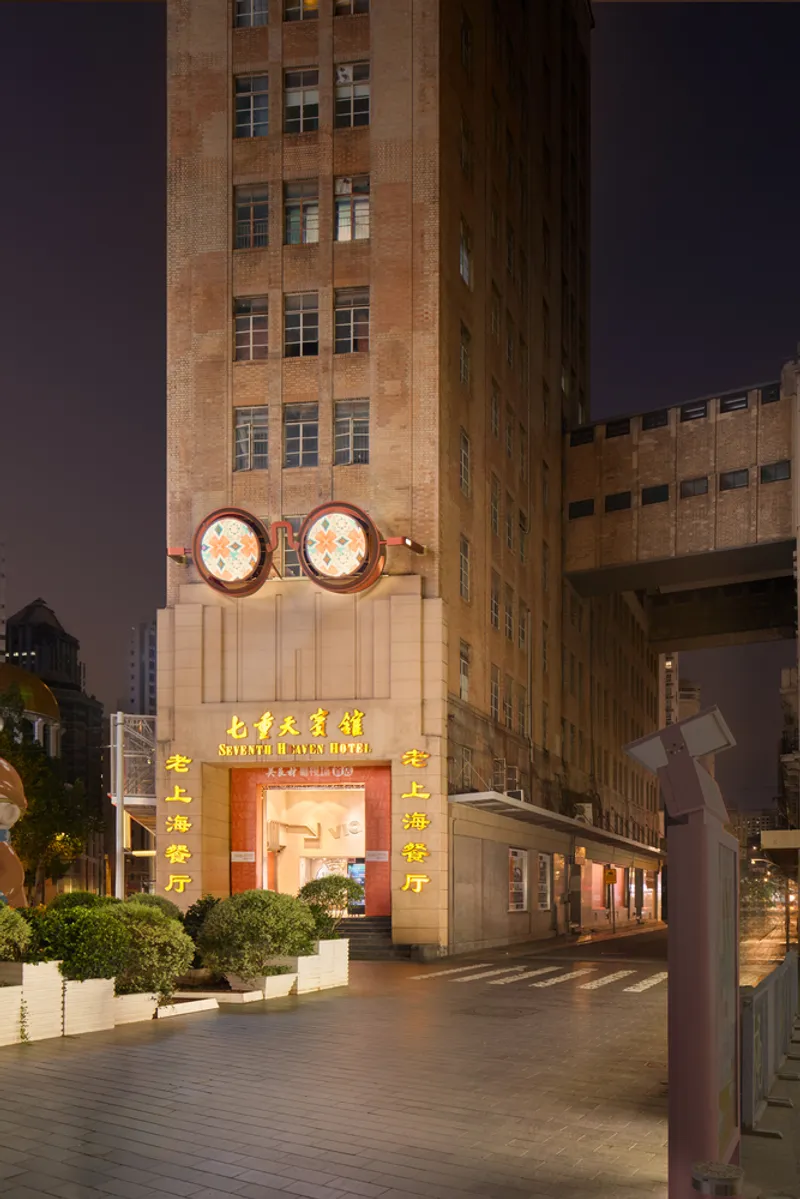 Hotel entrance with two oversized circular light fixtures mounted above the doorway at twilight