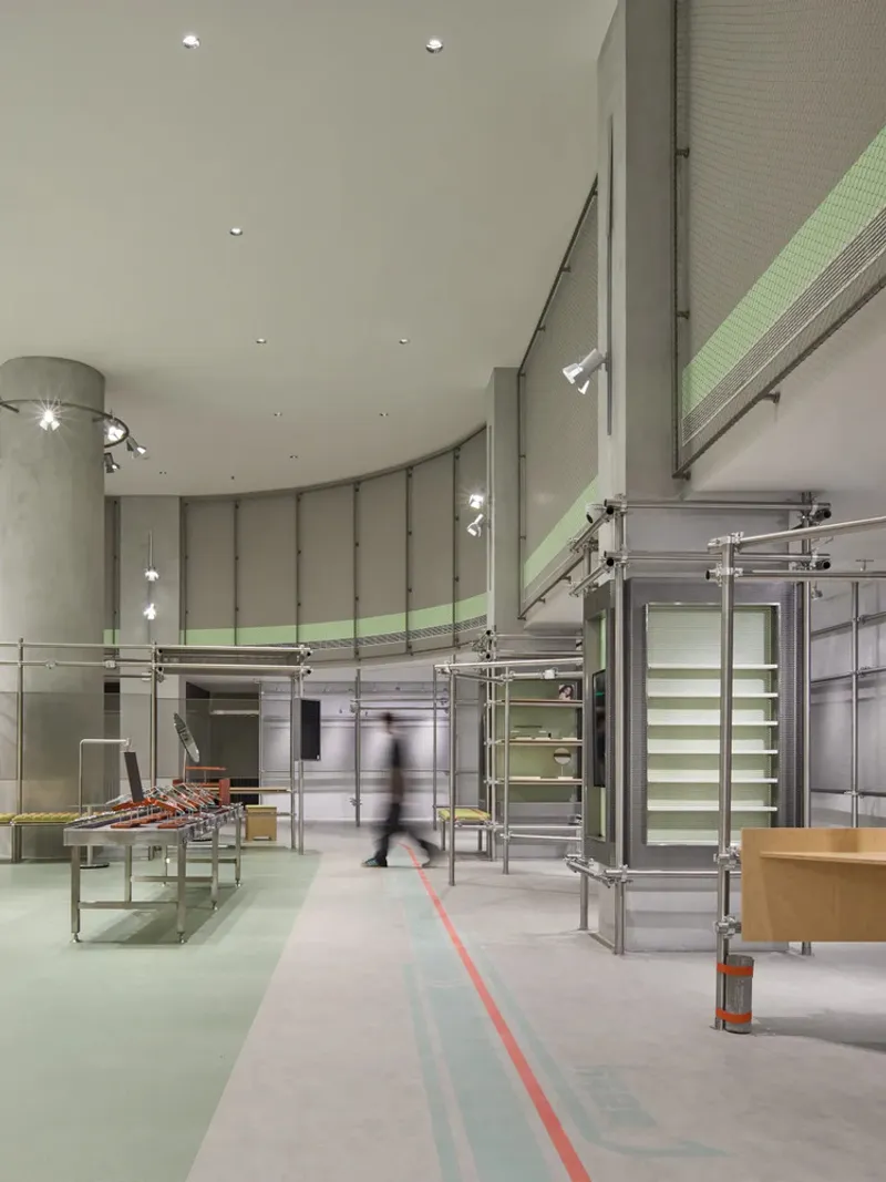 Interior lobby with modular steel shelving units and curved walls with pale green accent bands