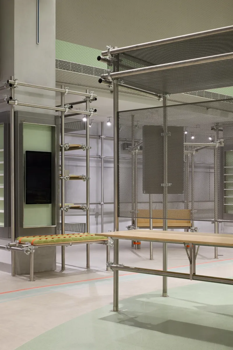 Tubular steel scaffolding system with ladder rungs and translucent partition panels between display zones