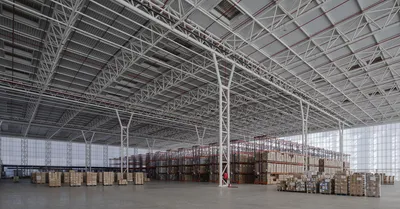 This architectural image showcases the interior of a large warehouse, characterized by its extensive