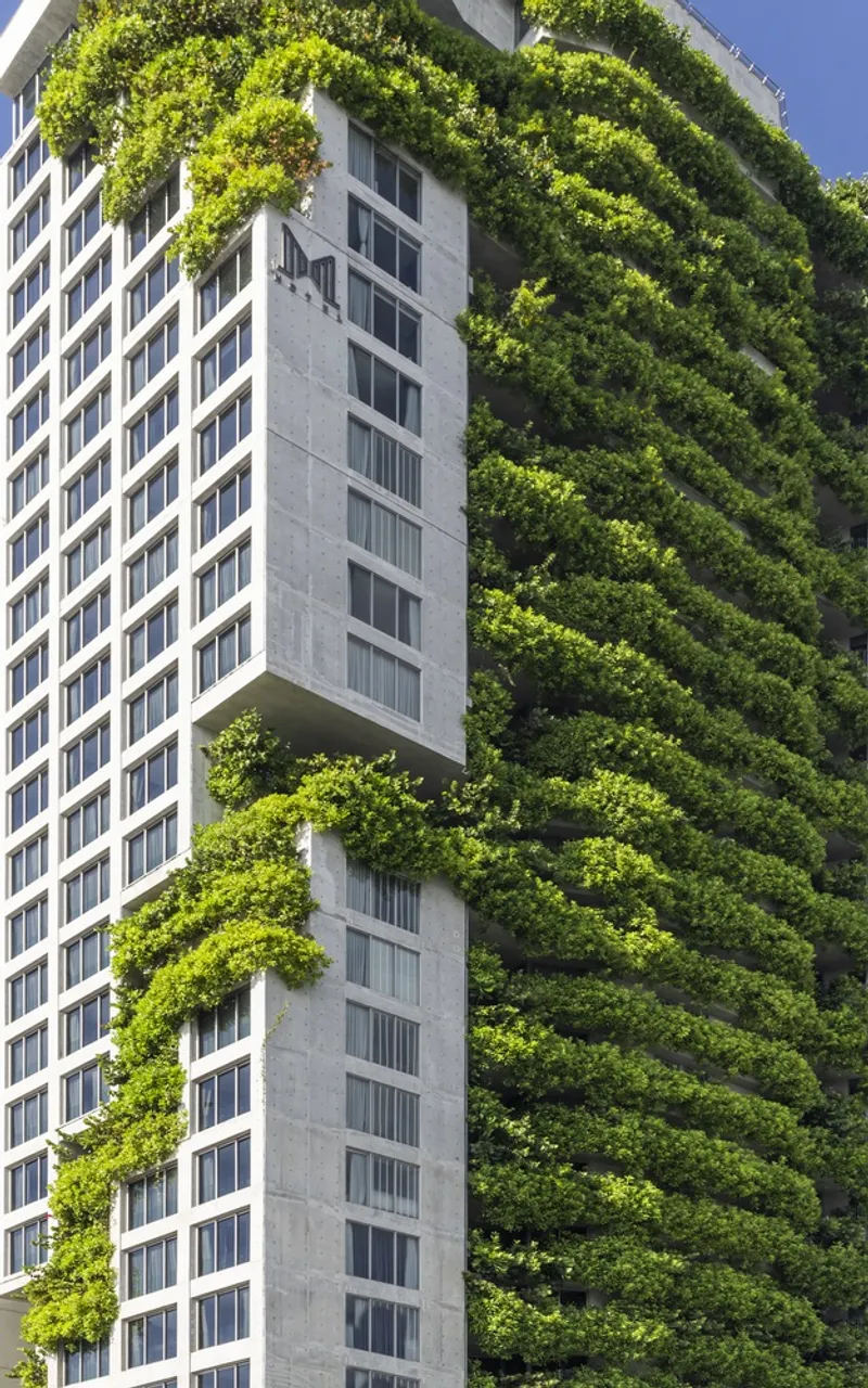 Close view of the planted balcony terraces wrapping around the concrete and glass facade volumes