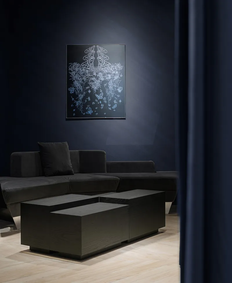 Seating area with charcoal sofa and backlit jellyfish artwork on a blue wall