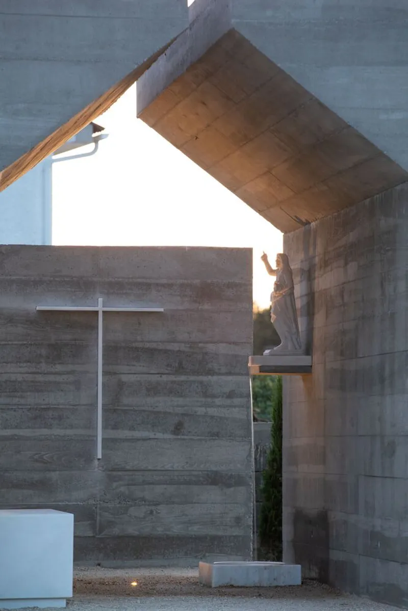 Angled view through the pitched concrete opening revealing the timber-formed interior ceiling
