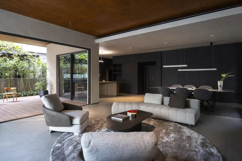 Open-plan living area with timber ceiling, sliding glass doors to deck and suspended linear lighting