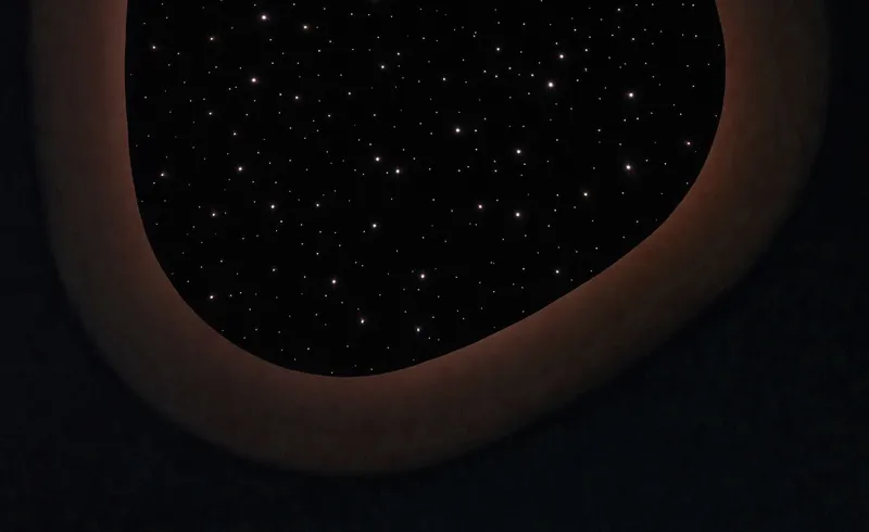 Close-up of the oval skylight opening with fiber optic star field and warm illuminated edge