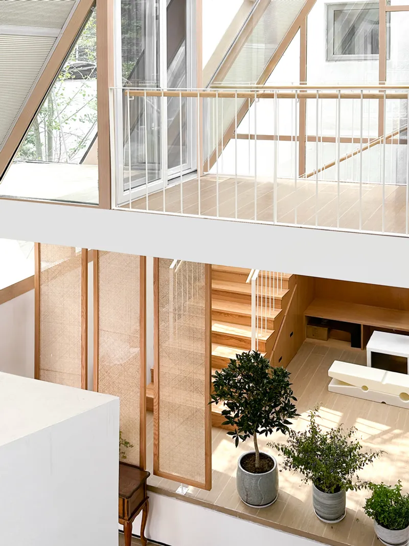 Upper-level mezzanine with timber guardrails overlooking planters and sliding screen panels