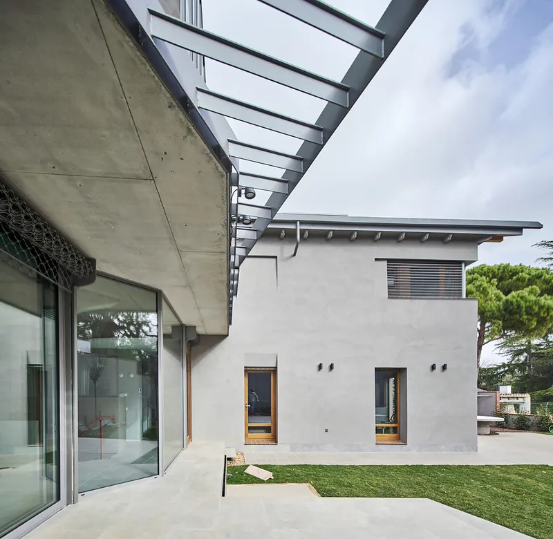 Detail of the pergola beams extending from the concrete soffit over the paved terrace