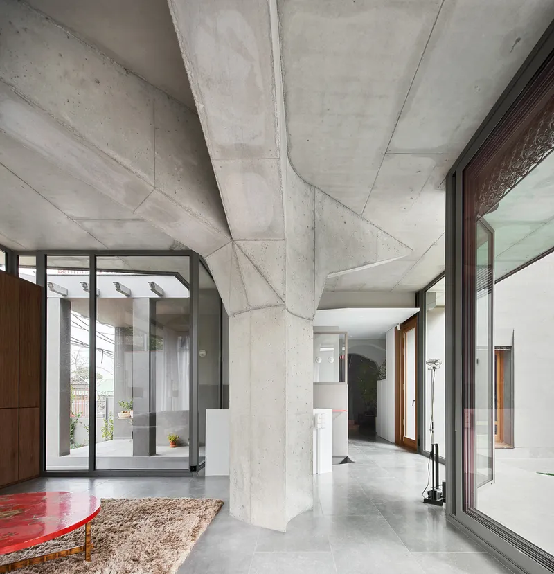Interior view of faceted concrete ceiling structure with polished concrete floors and courtyard glazing beyond
