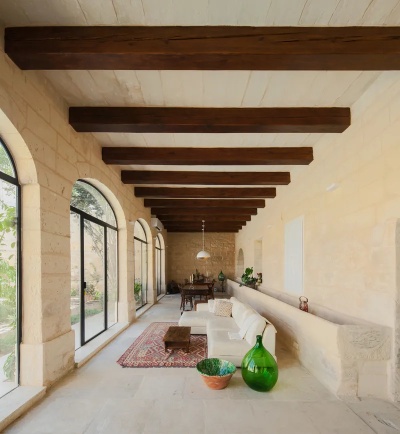 Interior hall with exposed timber beams and arched openings to the courtyard