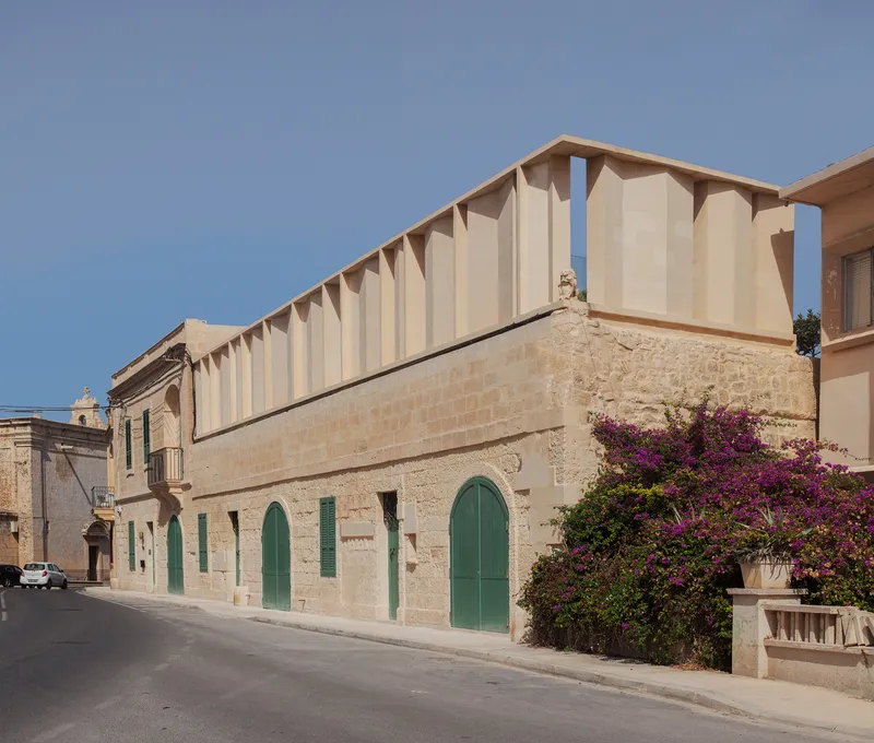 Long view of the timber colonnade roofline with bougainvillea below under clear sky