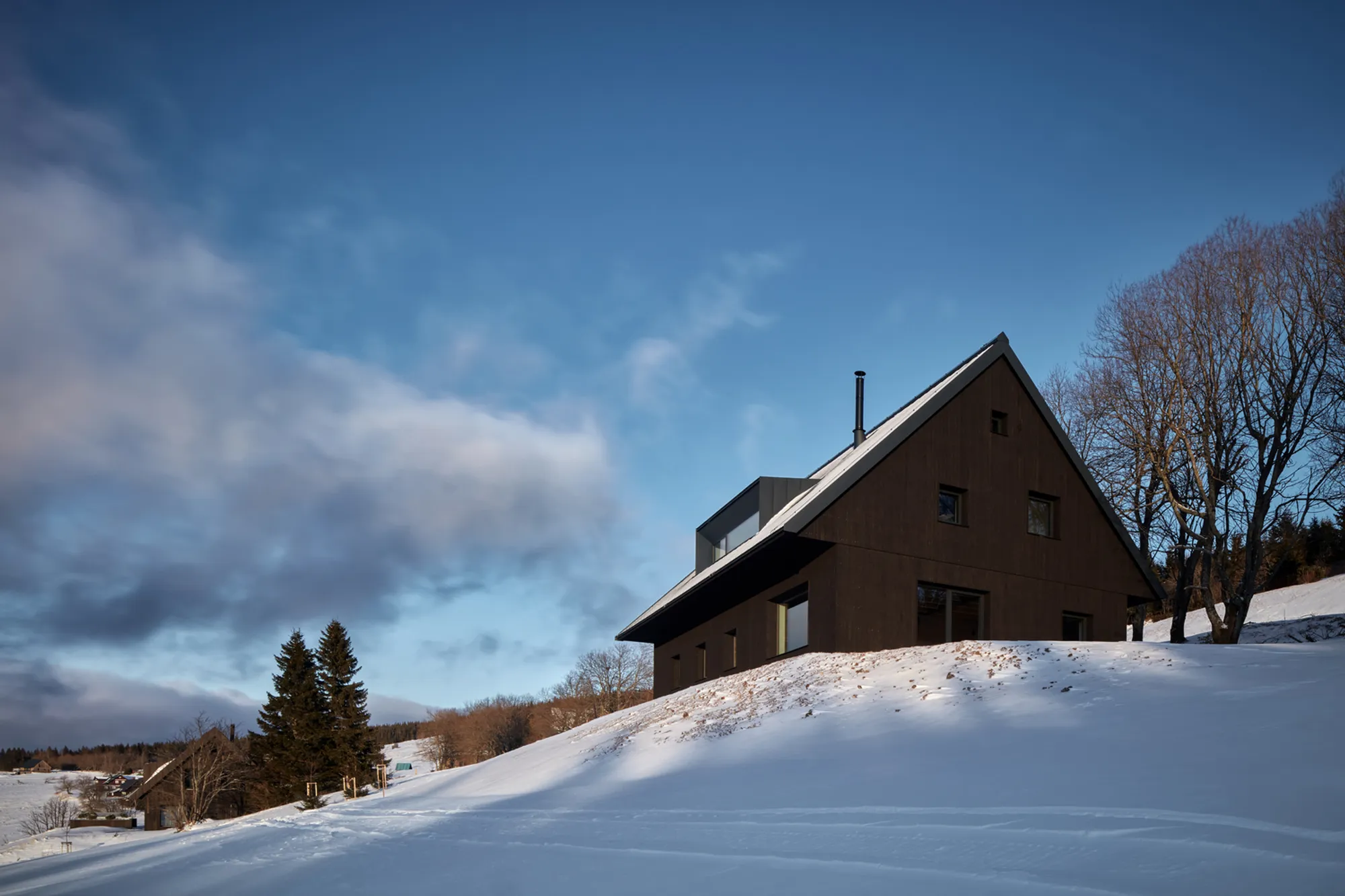 ADR Builds a Black Timber Cottage on a Czech Ski Slope with Three Sleeping Lofts Inside Its Gable