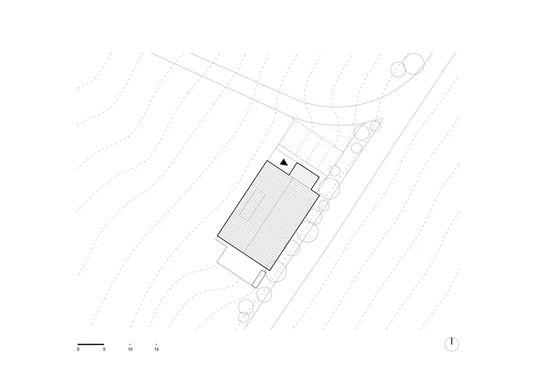 Site plan drawing showing a single building footprint on sloped topography with contour lines