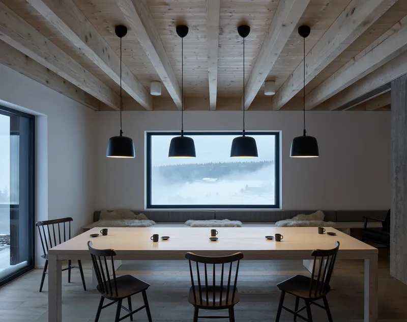Dining area with horizontal window framing a misty forest hillside view