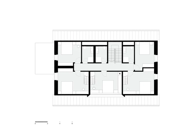 Floor plan drawing showing a rectangular volume with rooms arranged around two central staircases and terraces