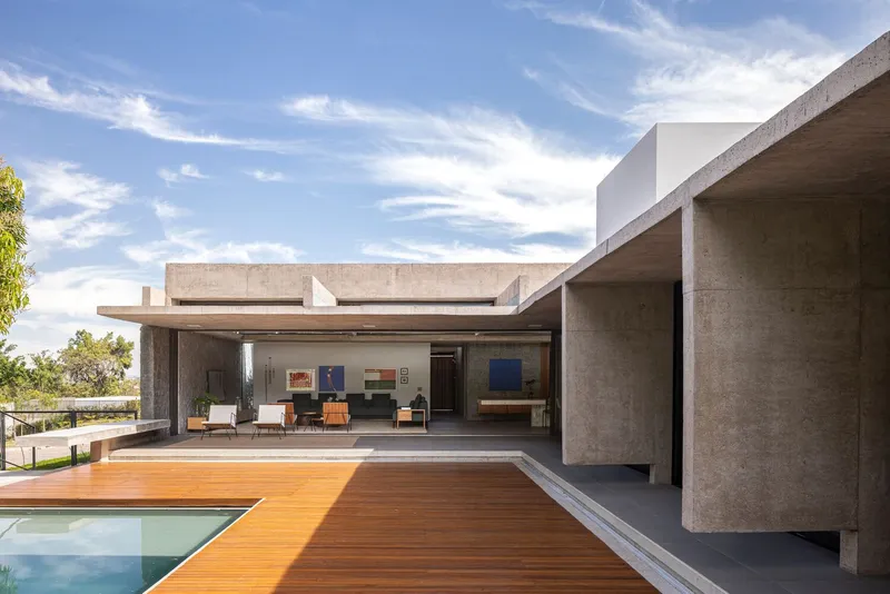Outdoor terrace with timber deck, pool edge, and concrete frame overlooking the landscape