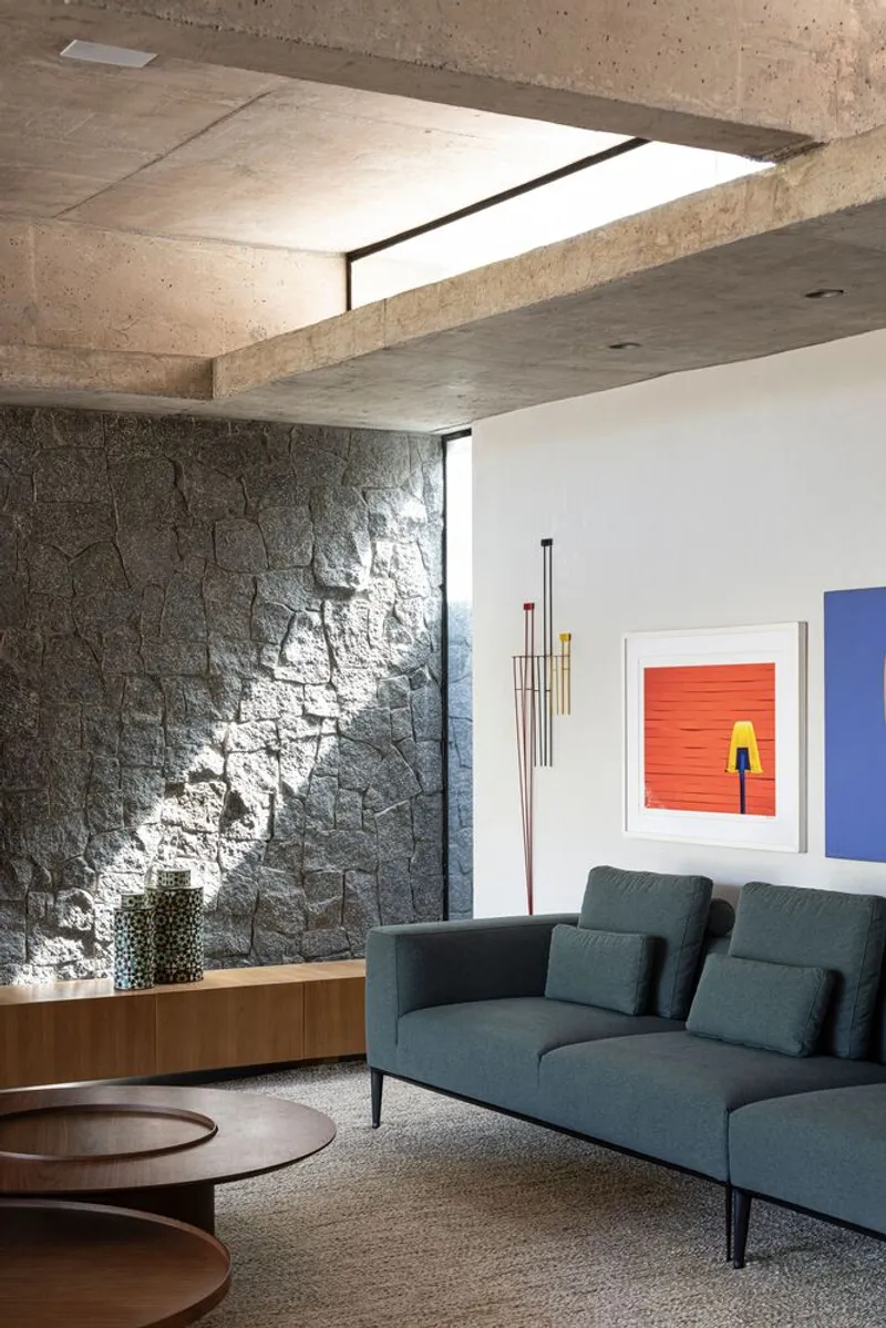 Living room corner showing stone wall with clerestory slot casting dappled afternoon light