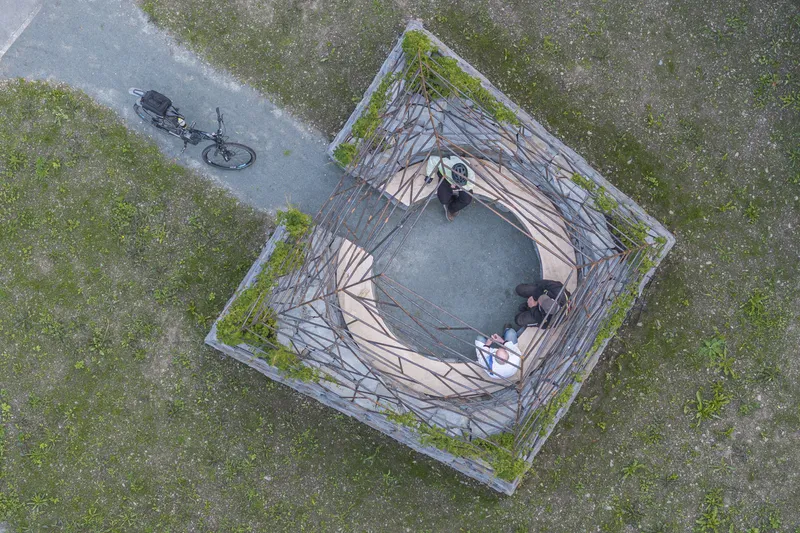 Aerial view of the circular stone seating area with layered slate walls and visitors at the center