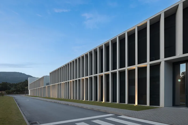 Street view of the colonnade facade with deep recessed openings framed by vertical concrete piers