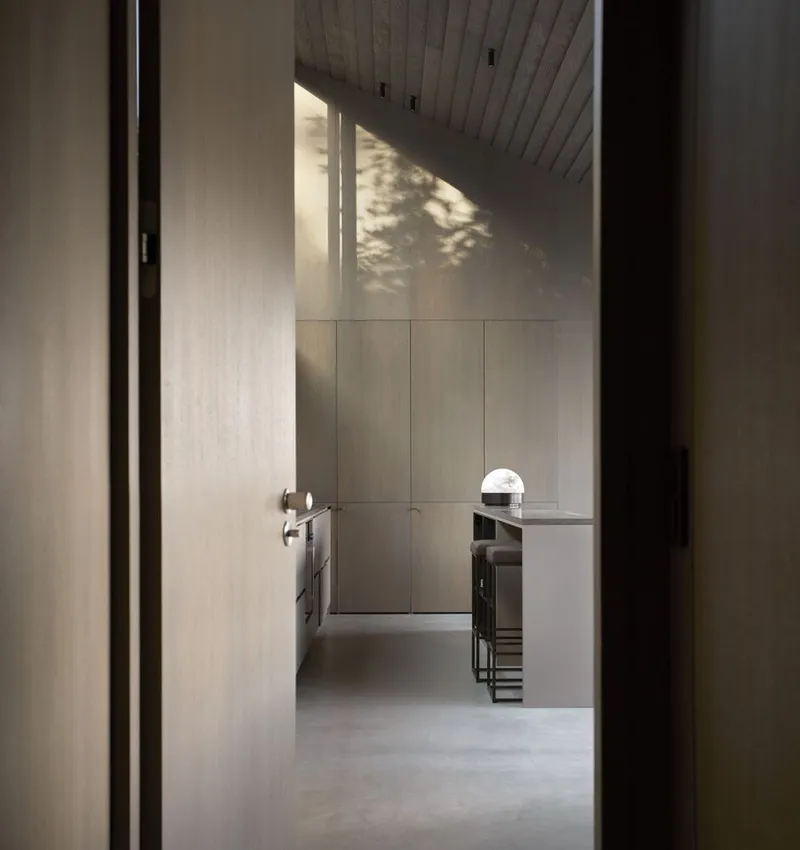 View through doorway into the kitchen with timber ceiling and dappled afternoon sunlight