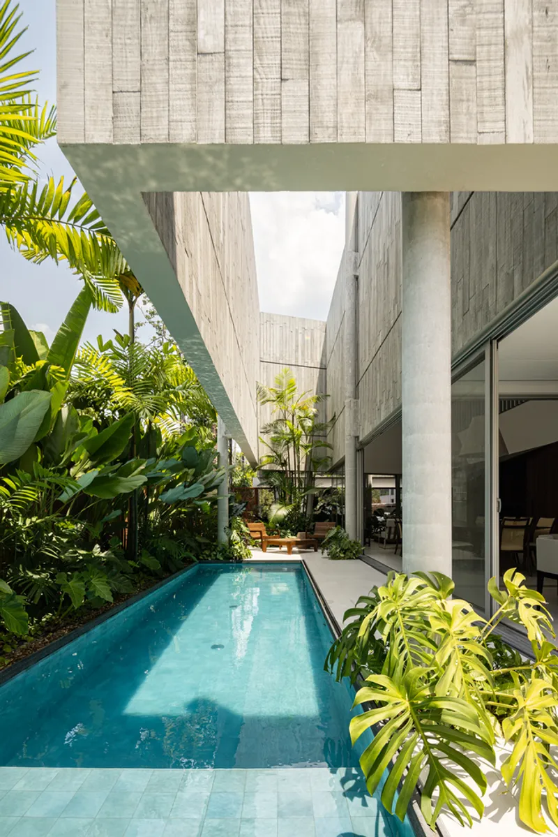 Narrow lap pool running alongside the board-formed concrete walls and planted courtyard