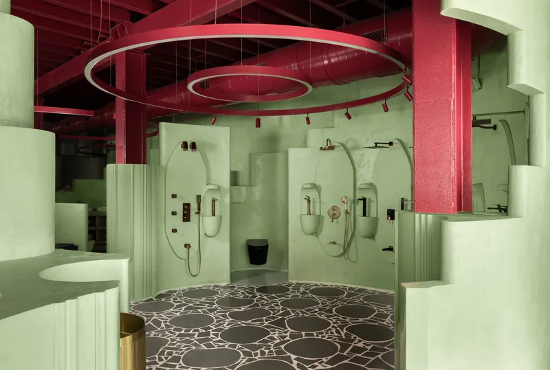 Shower area with three arched niches set into pale green walls below circular hanging light fixtures