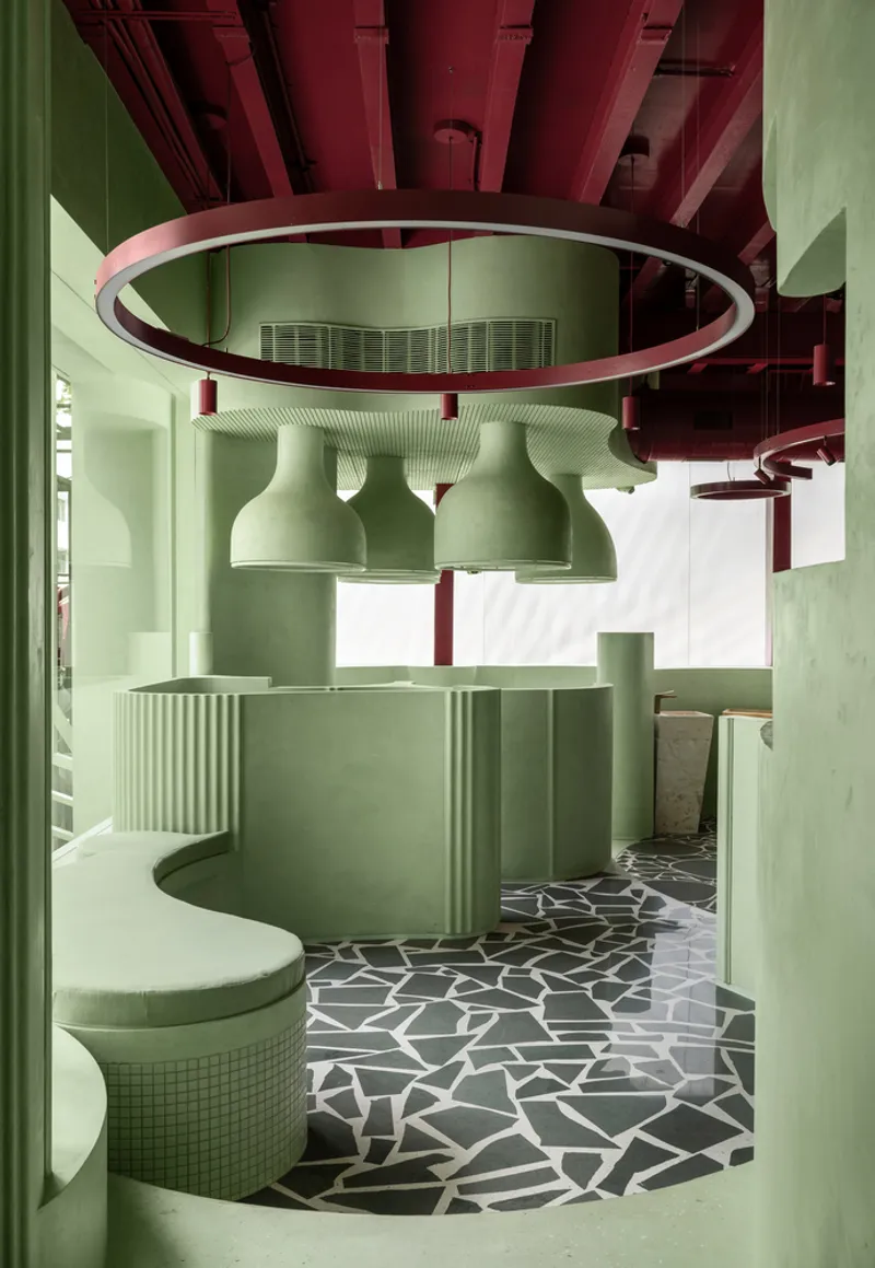 Reception counter with fluted detailing beneath vaulted ceiling forms and a suspended circular lighting ring