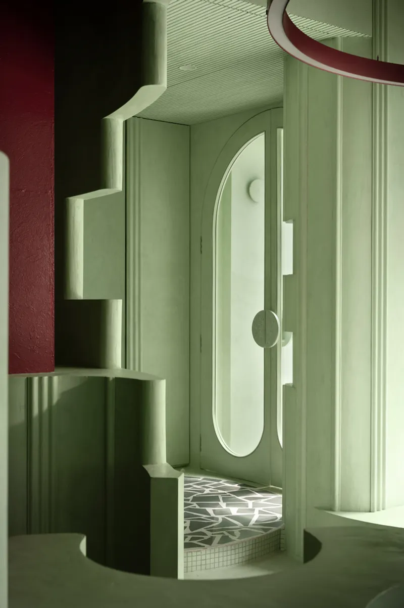 Arched doorway framed by fluted pilasters and wall niches casting shadows across the threshold