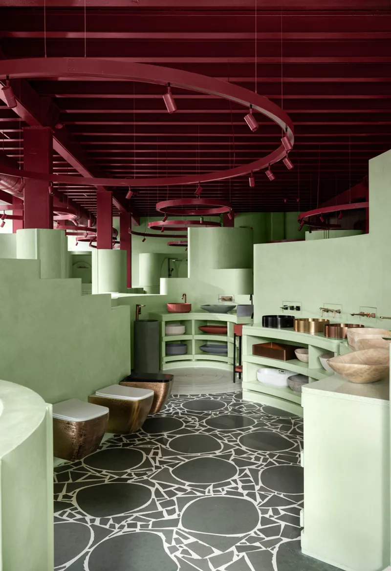Spa interior with curved green partitions, wooden stools and patterned stone floor tiles