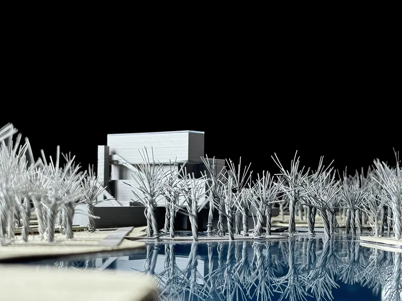 Physical model showing a horizontal volume reflected in a water plane surrounded by white wire trees