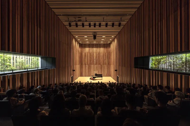 Vertical timber slat walls framing horizontal clerestory windows with views to green foliage outside