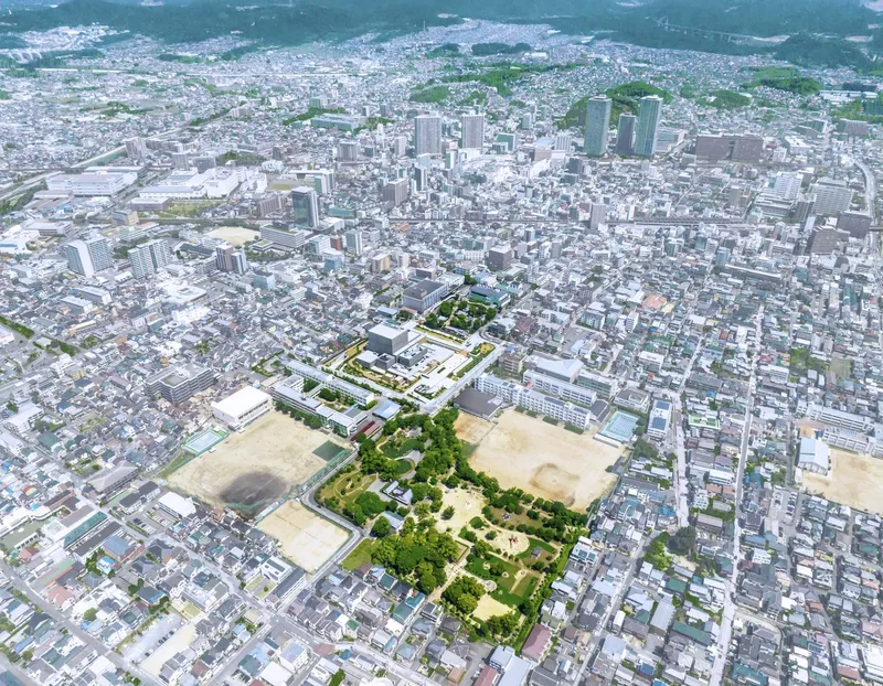 Aerial view of a cultural complex with rooftop gardens surrounded by dense urban residential and commercial development