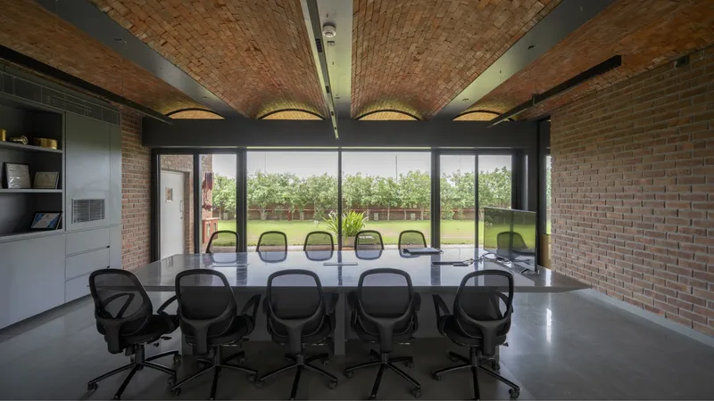 Conference room with brick vaulted ceiling and glazed wall overlooking a lawn