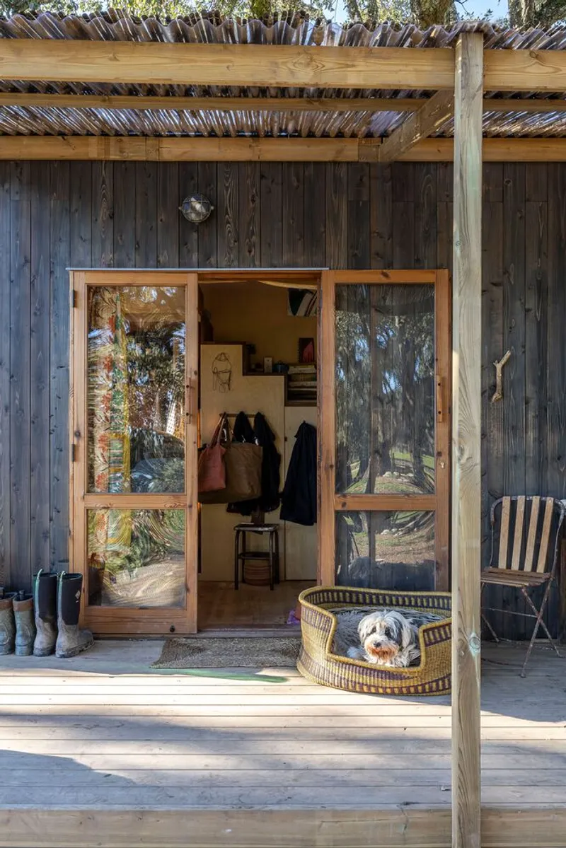 Entry doors framed in timber with a dog resting in a basket on the deck