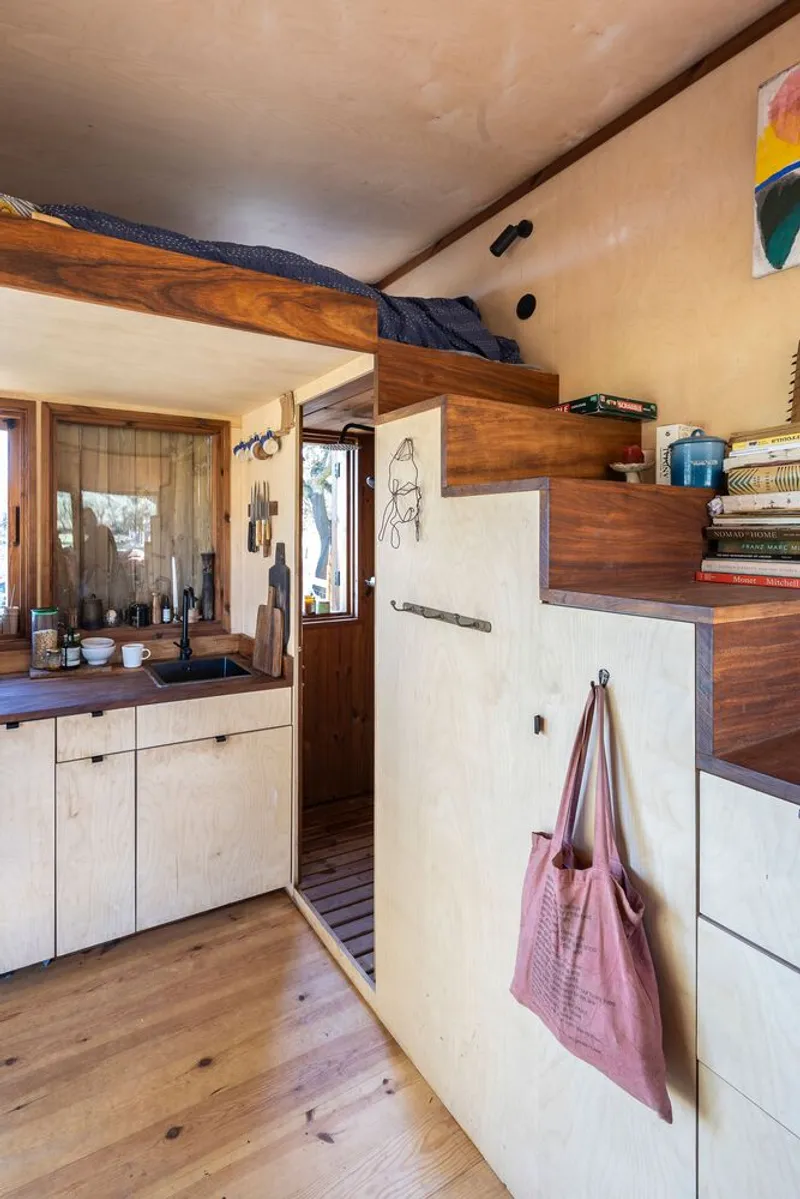 Interior view showing plywood cabinets and storage loft above the kitchen counter
