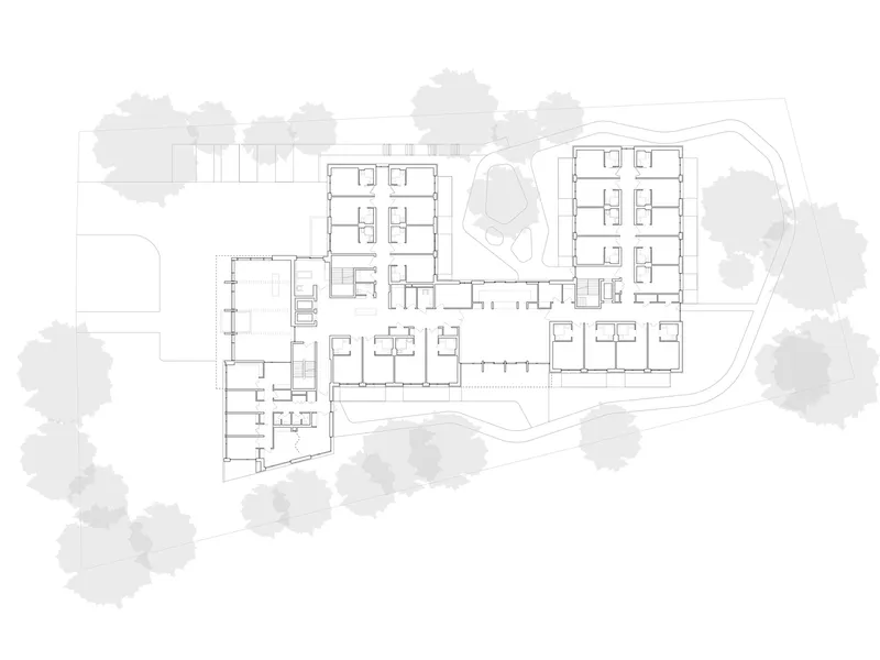 Upper floor plan drawing showing residential units flanking a central courtyard with surrounding trees