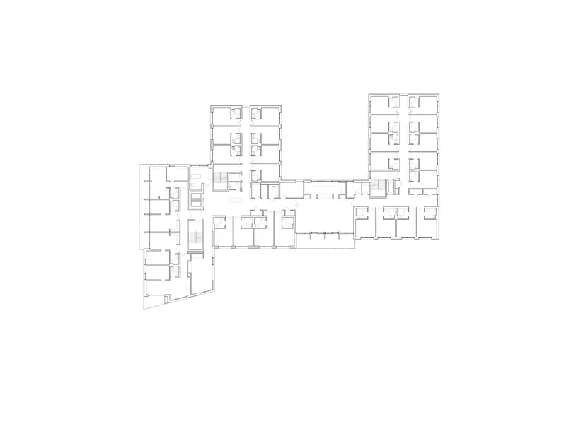 Floor plan drawing showing residential wings arranged around circulation cores and common spaces