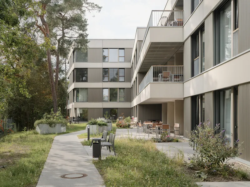 Garden terrace with seating and planters nestled between the offset residential wings