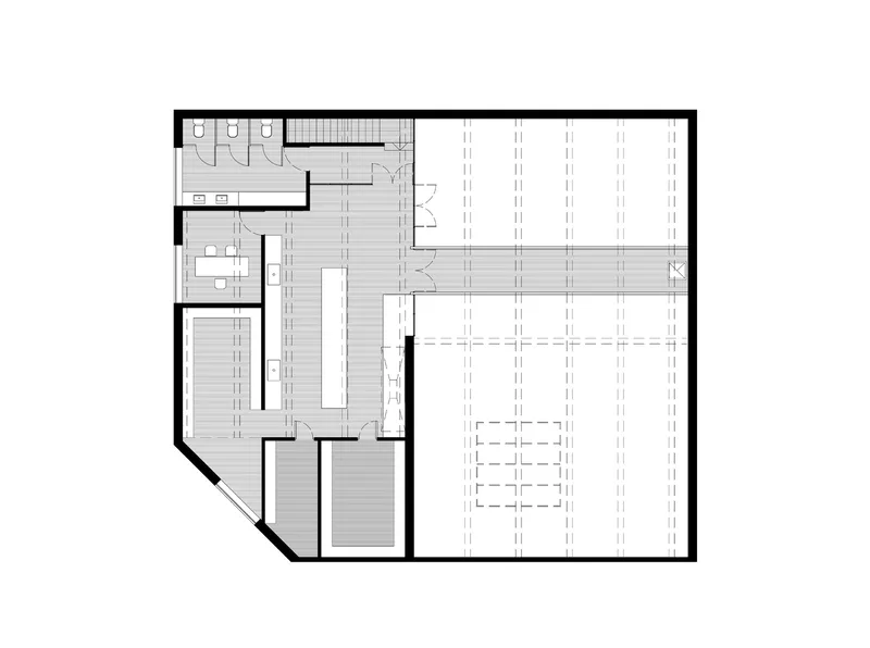 Floor plan drawing showing restrooms, workspaces, and a large open area with structural grid