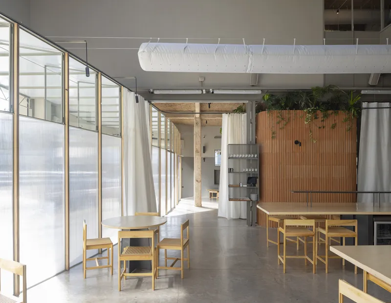 Long view through dining hall showing translucent wall panels, timber slat screen and suspended paper lamps