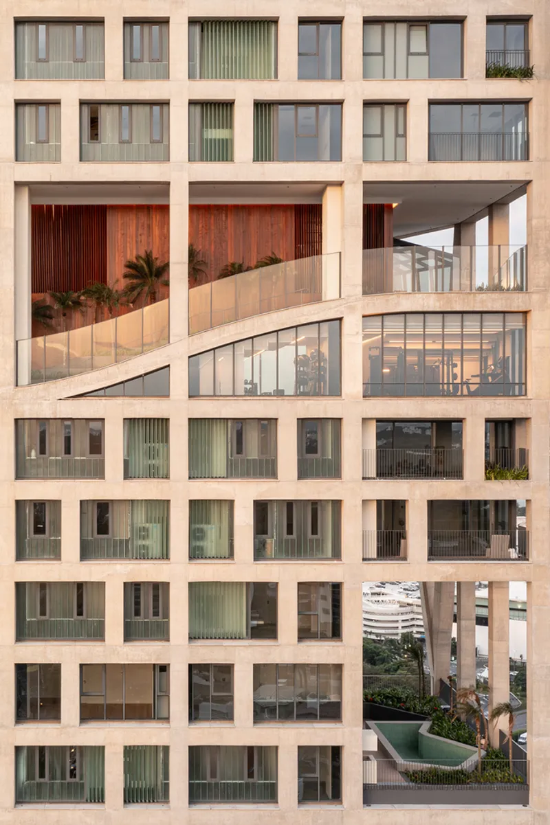 Tower facade showing stacked residential units with planted terraces and timber screens within the diagonal grid structure