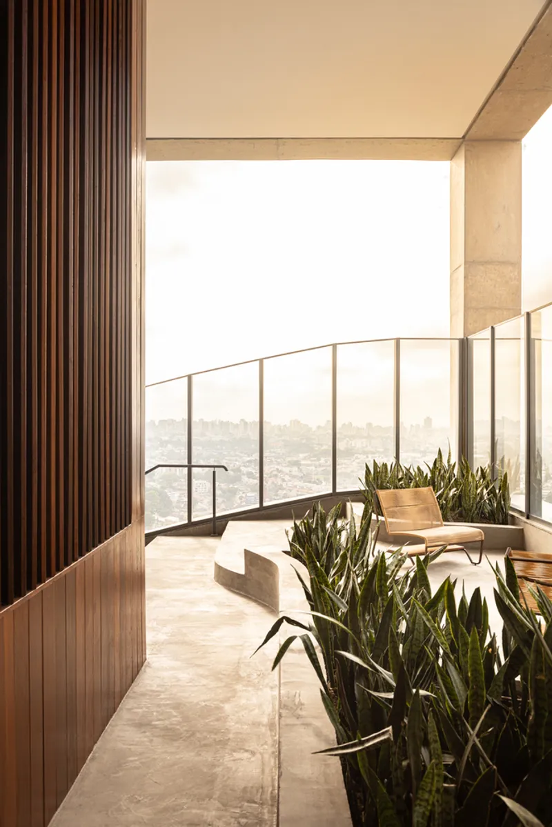Open terrace with vertical timber screen, metal railing, and planted pots overlooking the cityscape