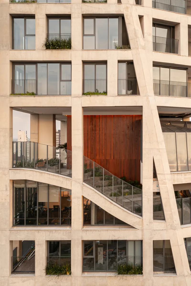 Facade detail showing diagonal concrete braces framing the glazed terrace with timber volume and staircase