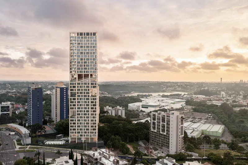 Elevated view of the slender tower rising above low-rise buildings and waterfront at sunset