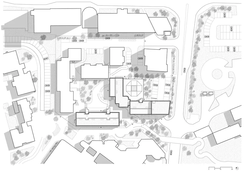 Site plan drawing depicting building footprints, landscaped areas and surrounding streets with trees and parking