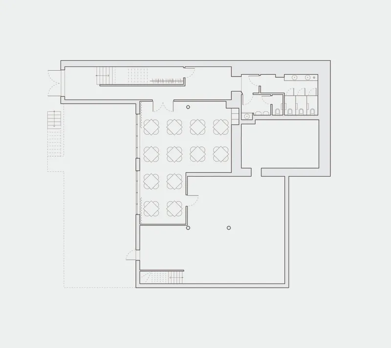Floor plan drawing depicting seating area with table arrangements, service zones, and staircase access