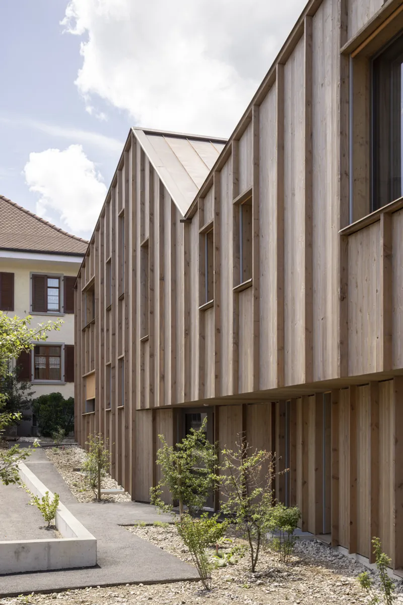 Detail of the vertical timber slat facade with planted gravel beds at its base