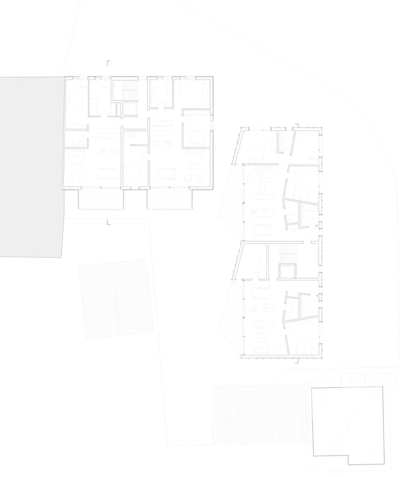 Floor plan drawing showing upper level with rectangular and curved wings containing divided interior spaces
