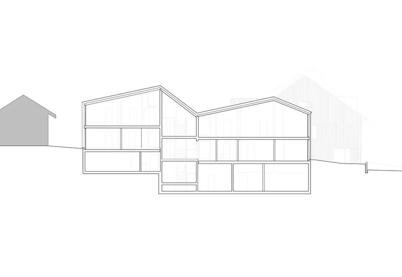 Section drawing showing split-level volumes with gabled roofs and adjacent context buildings