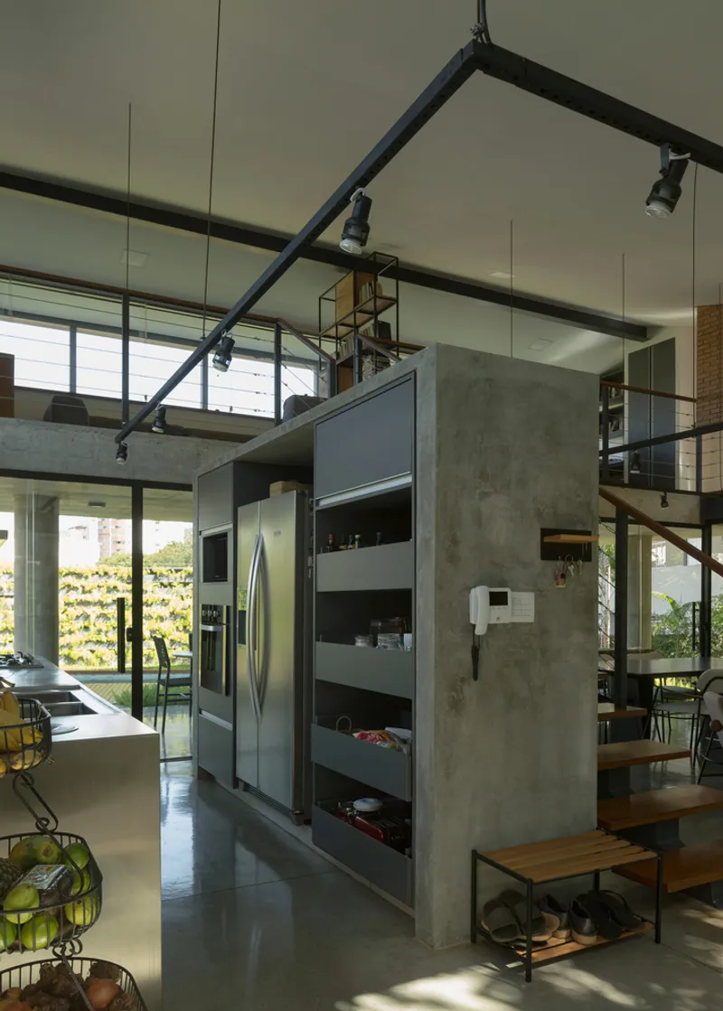 Open kitchen with concrete walls, exposed steel beams and clerestory windows overlooking vertical garden wall