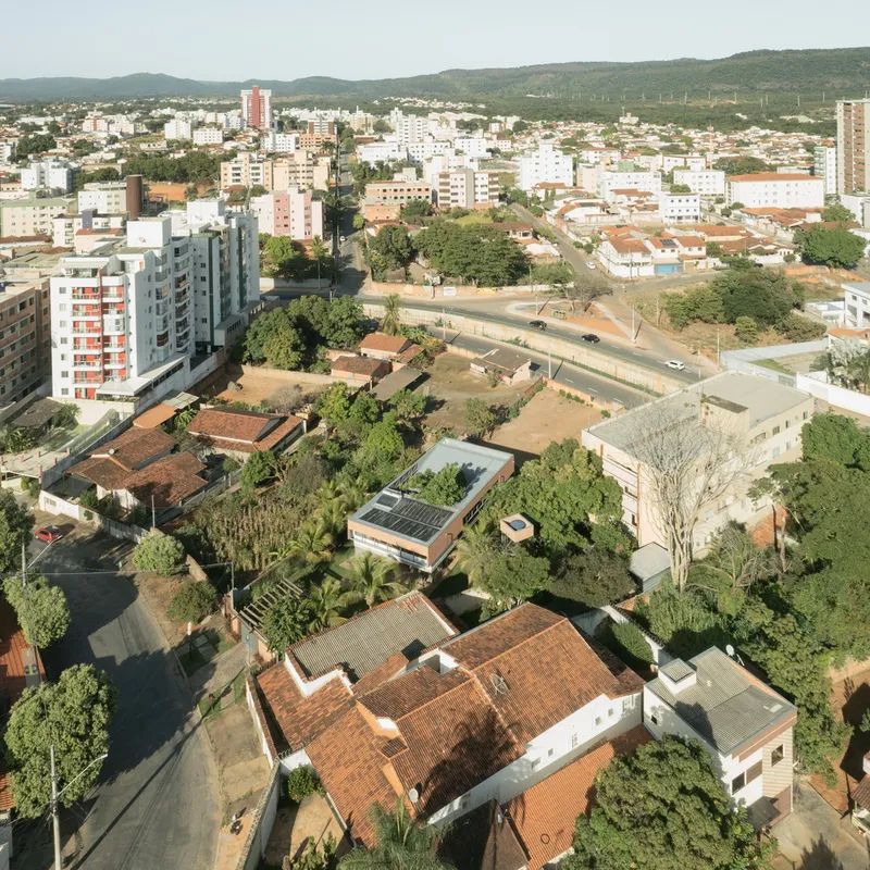 Aerial view of a residential neighborhood showing tile roofs and gardens among scattered trees and apartment blocks